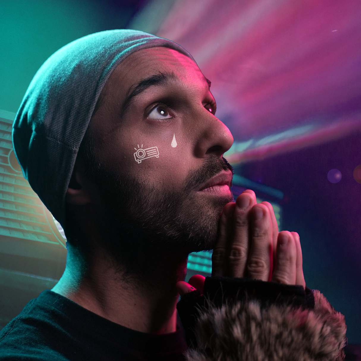 A colourful image of a man looking up at the light in front of projector in prayer.