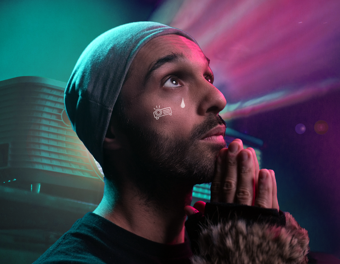 A colourful image of a man looking up at the light in front of projector in prayer.